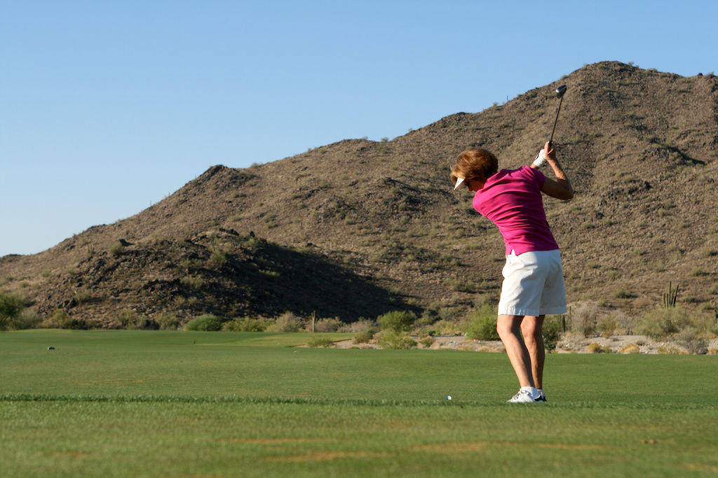 Woman taking swing at golf ball on Phoenix golf course
